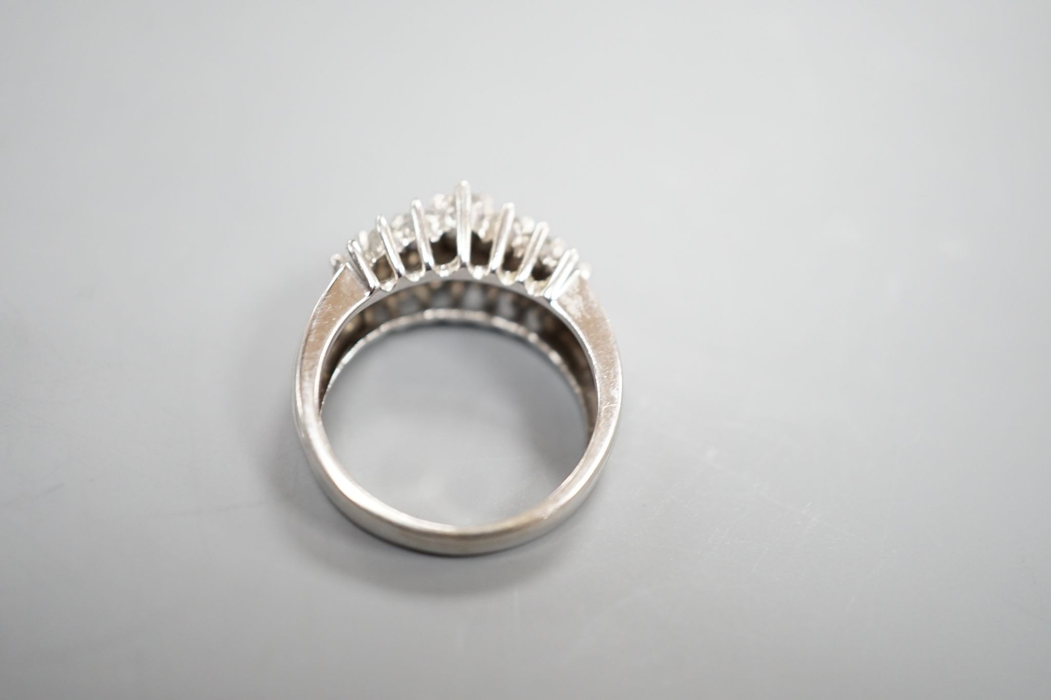 A modern 10k white metal and three row graduated diamond cluster set dress ring, size L, gross weight 4.3 grams.